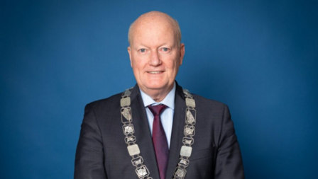 Portretfoto op blauwe achtergrond van burgemeester Ruud van Bennekom