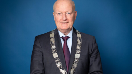 Portretfoto op blauwe achtergrond van burgemeester Ruud van Bennekom