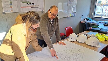 Wethouder krijgt uitleg van aannemer over de verbouwing 