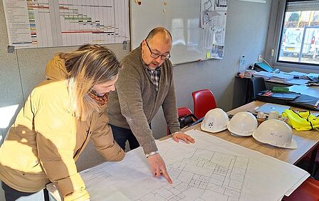 Wethouder krijgt uitleg van aannemer over de verbouwing 